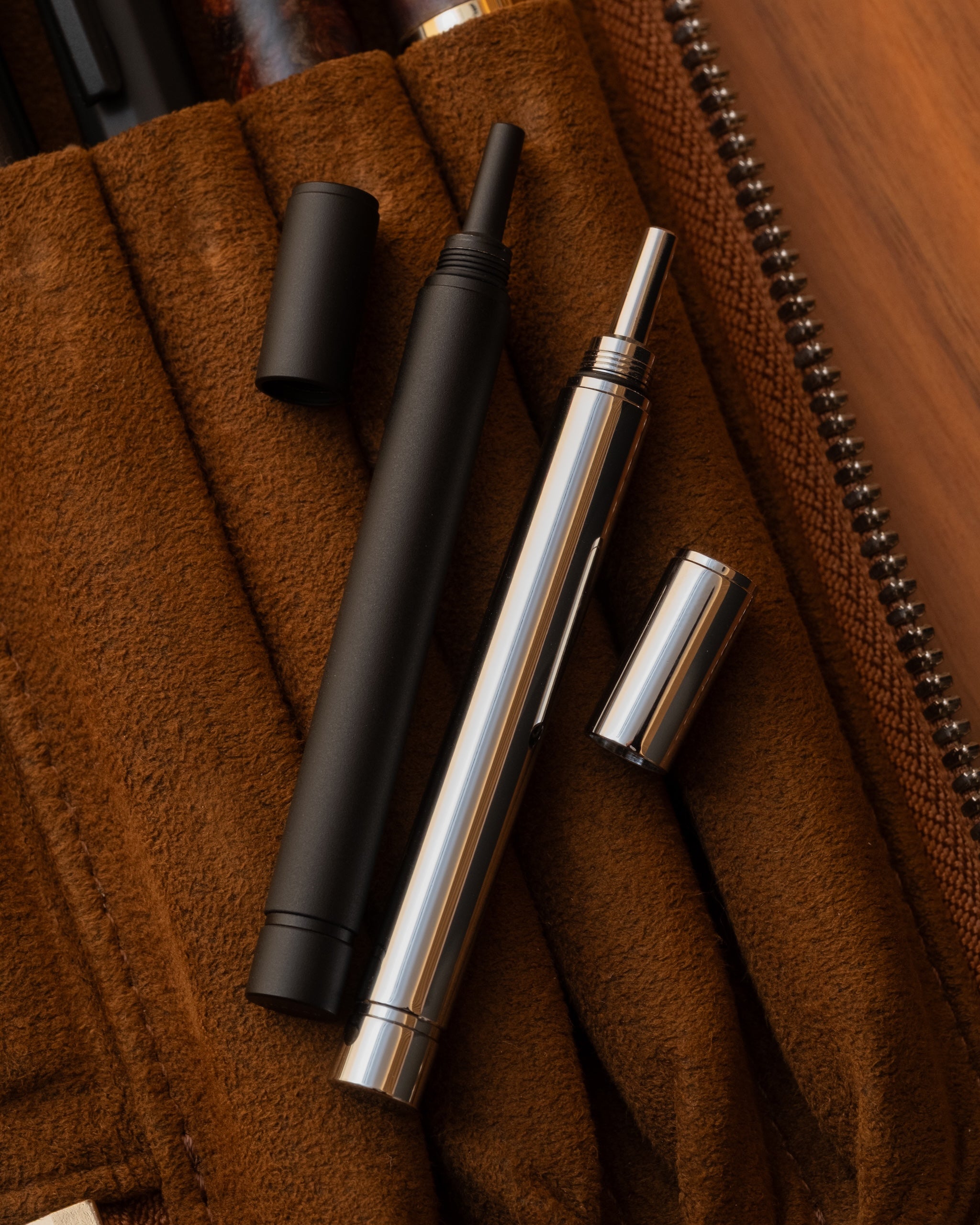 SEASAR DIJECT 芯ケース ブラックとシルバーを分解し、レザーペンケースDUCTの上に並べたライフスタイルイメージ