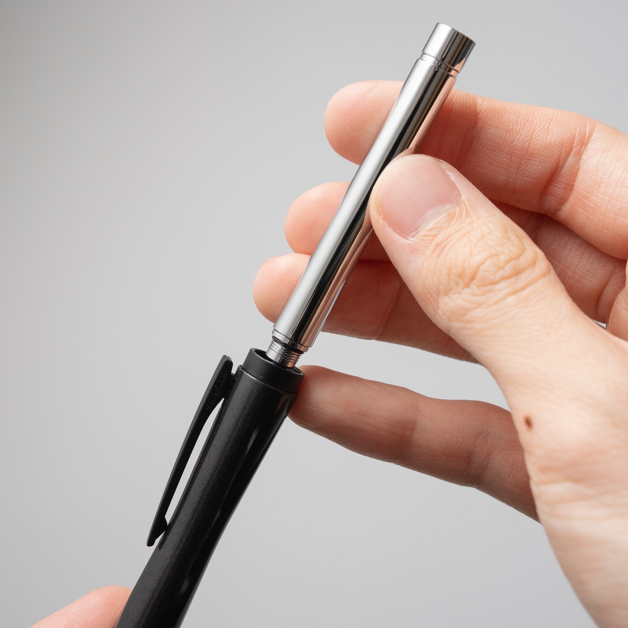 SEASAR DIJECT 芯ケース シルバーを使用して、シャーペンへ芯を直接補充・装填している手元の様子